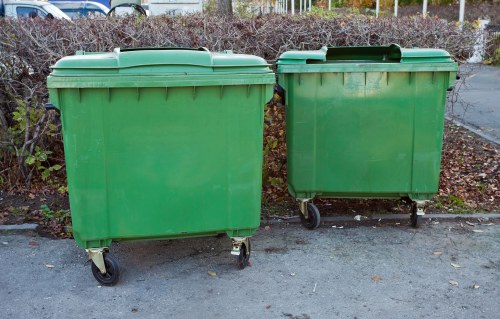 Operatives wearing high-visibility PPE loading a skip
